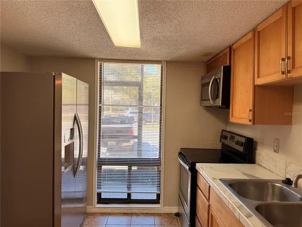 a kitchen with a refrigerator a sink and a window