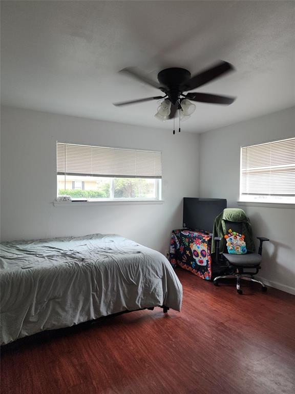 1714 Laurel Road Gainesville, TX 76240 - Photo 5 of 11 Bedroom with multiple windows, wood finished floors, and a ceiling fan