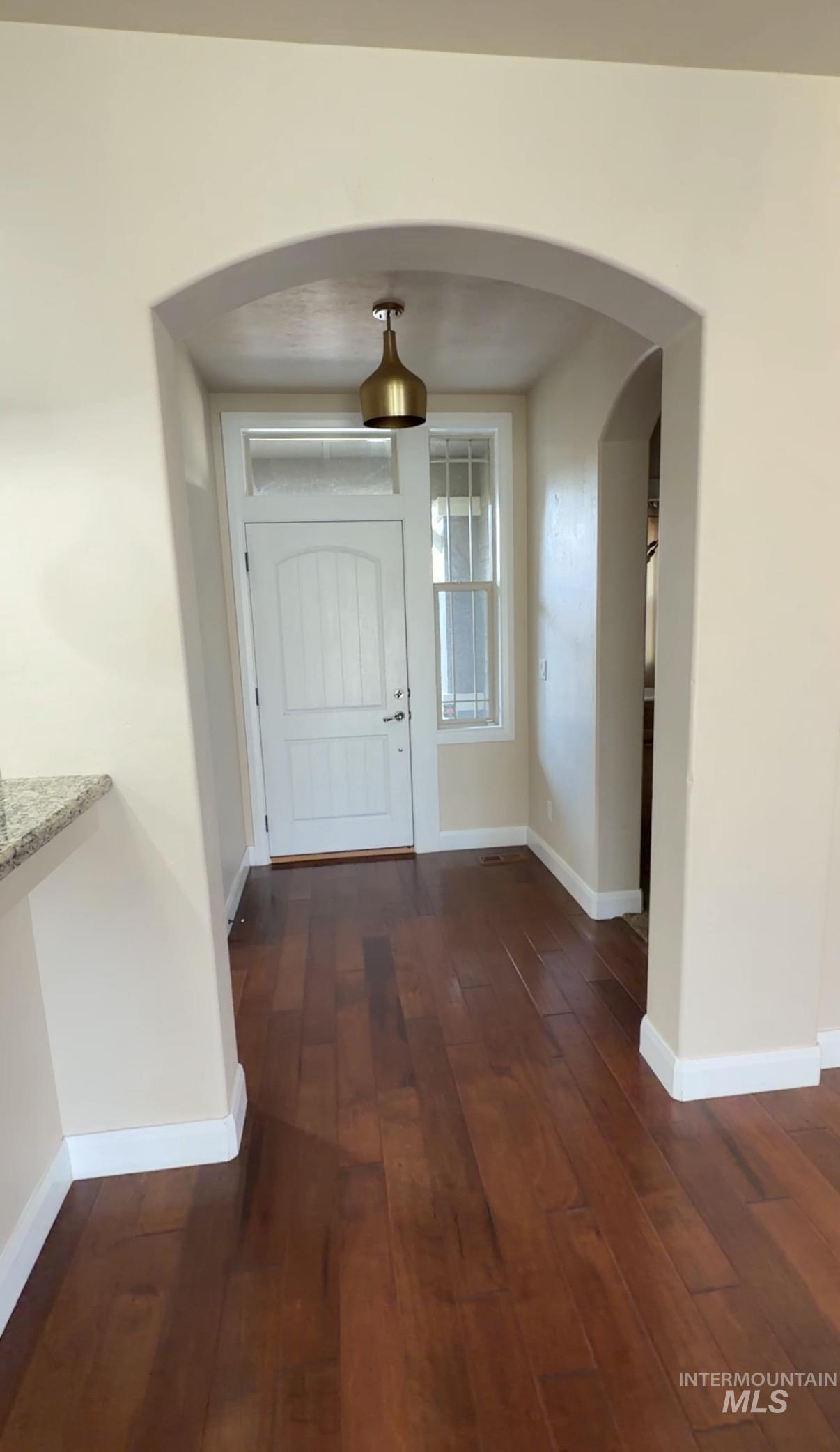 4678 North Elmstone Avenue Meridian, ID 83646 - Photo 2 of 15 Foyer featuring arched walkways and dark wood finished floors