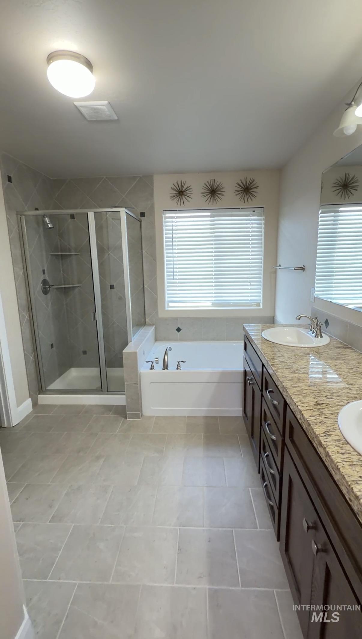 4678 North Elmstone Avenue Meridian, ID 83646 - Photo 7 of 15 Bathroom featuring a bath, double vanity, and a shower stall