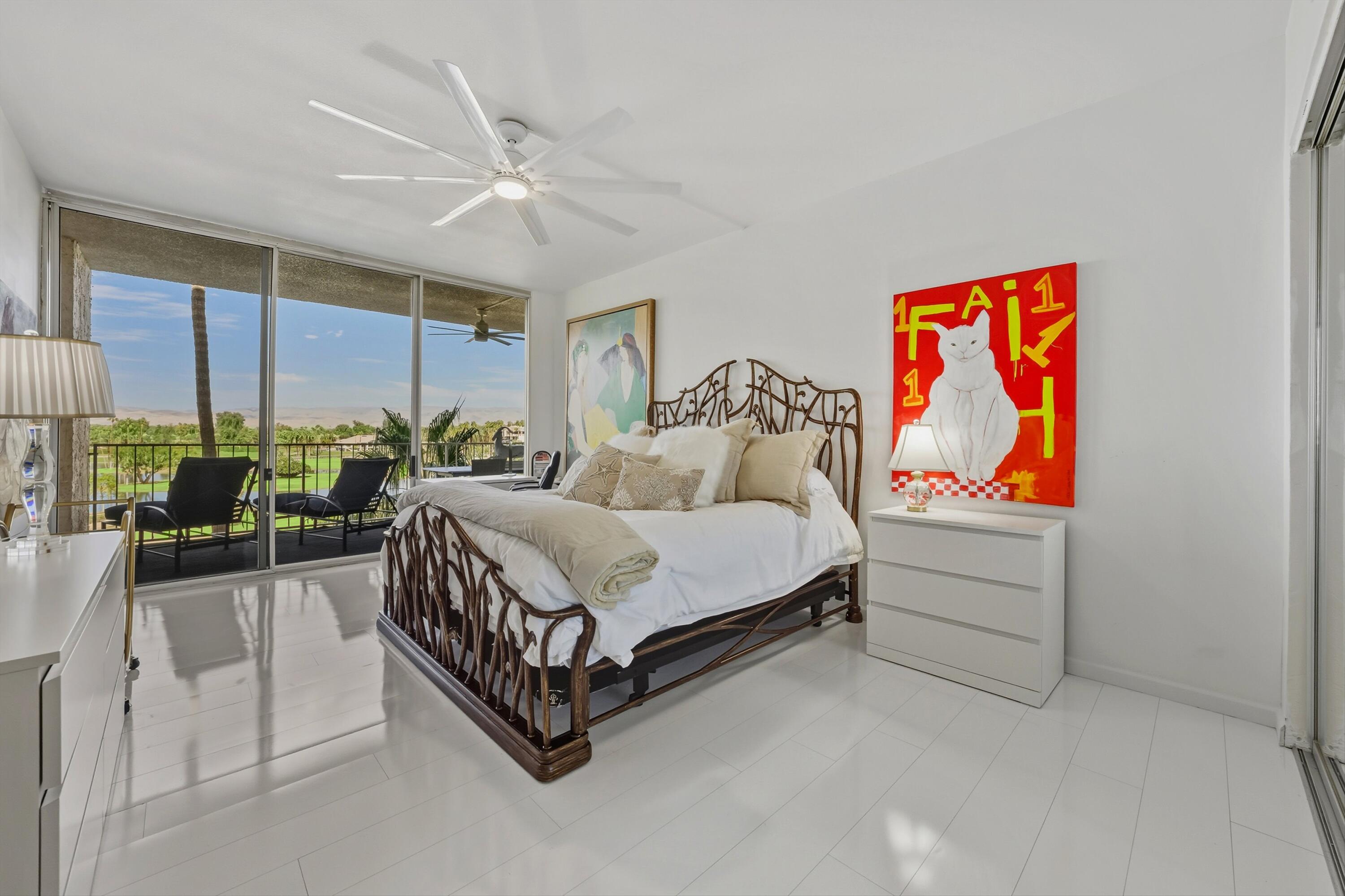 899 Island Drive, Unit 509 Rancho Mirage, CA 92270 - Photo 16 of 32 a spacious bedroom with a bed and a painting on the wall