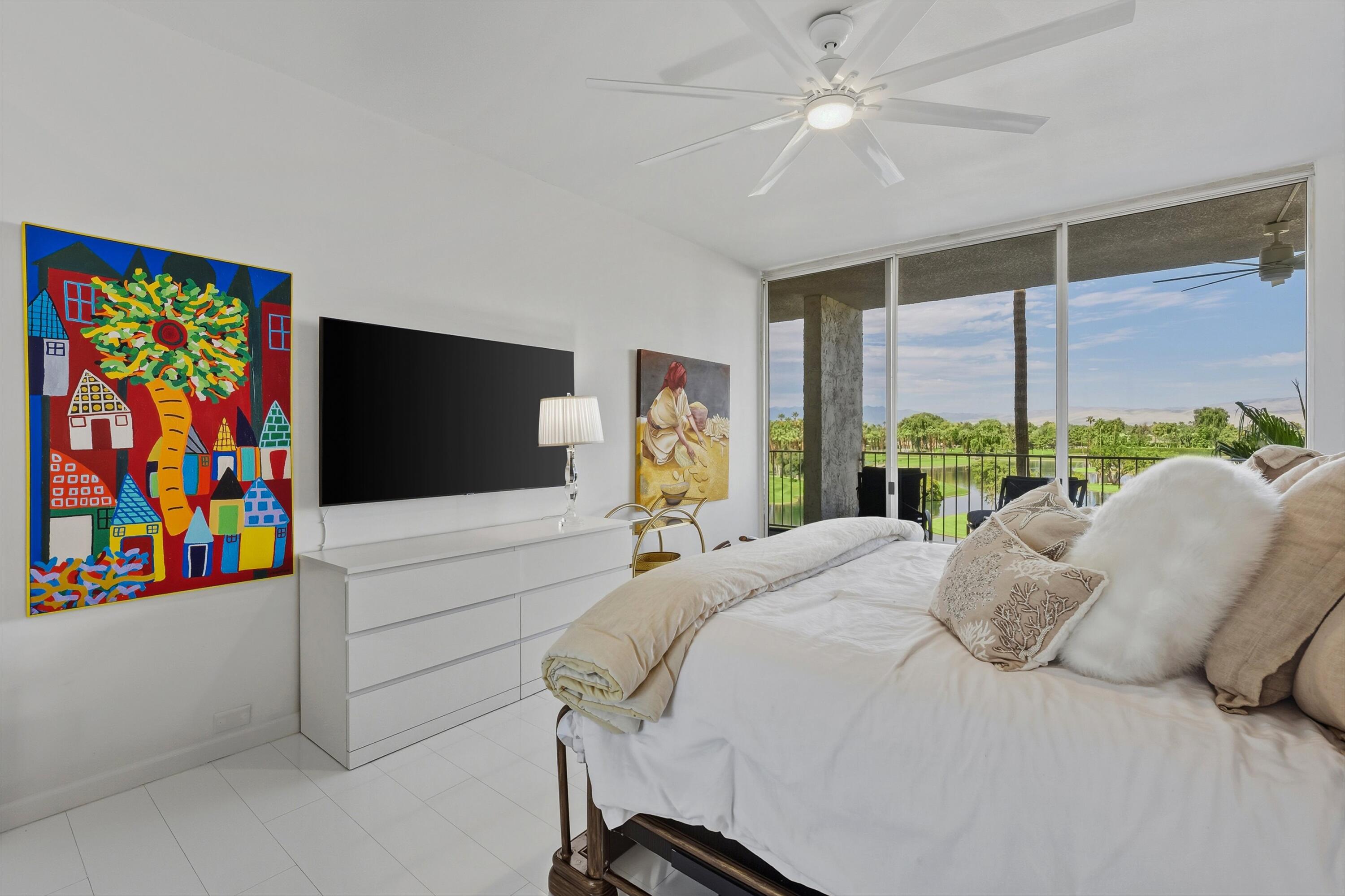 899 Island Drive, Unit 509 Rancho Mirage, CA 92270 - Photo 17 of 32 a bedroom with a bed and a large window