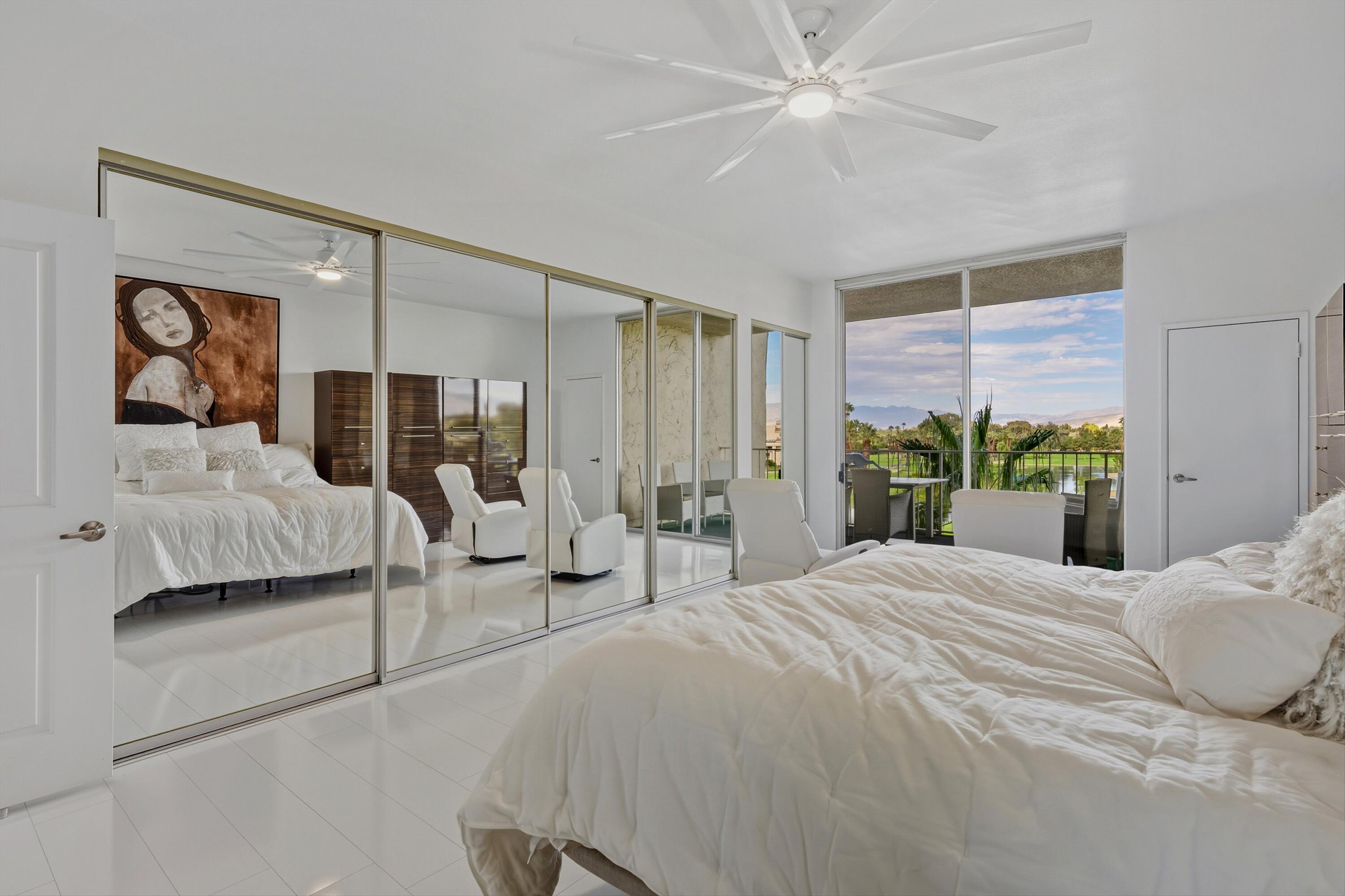 899 Island Drive, Unit 509 Rancho Mirage, CA 92270 - Photo 21 of 32 a bedroom with a large bed and a chandelier