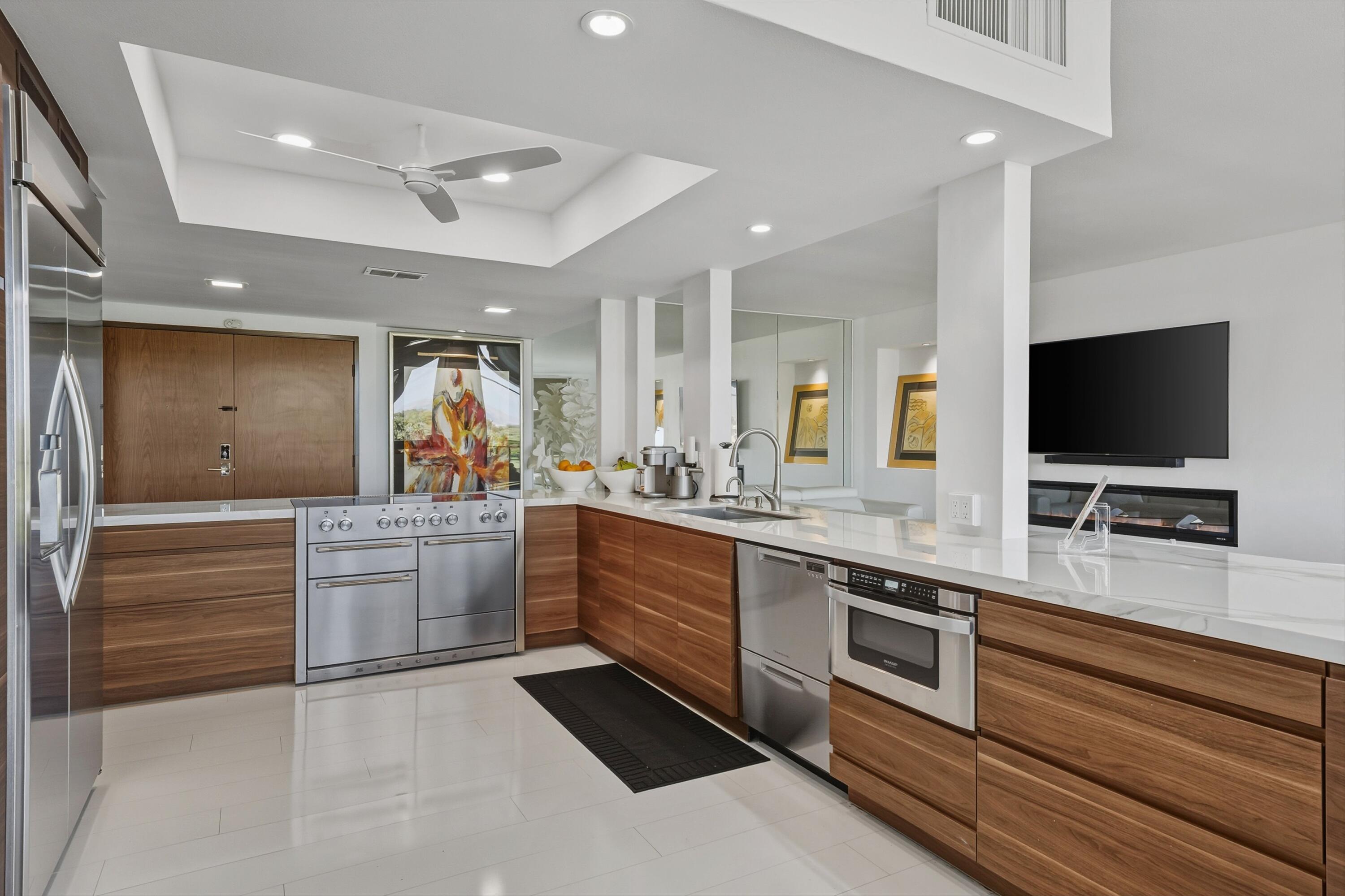 899 Island Drive, Unit 509 Rancho Mirage, CA 92270 - Photo 10 of 32 a large white kitchen with a sink and a stove top oven