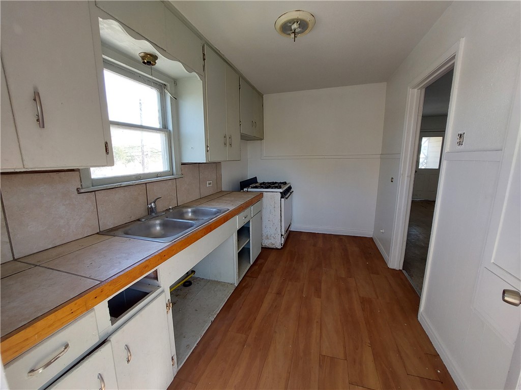1731 15th Street Corpus Christi, TX 78404 - Photo 5 of 20 a kitchen with sink a window and wooden floor