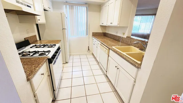 a kitchen with white cabinets and white appliances