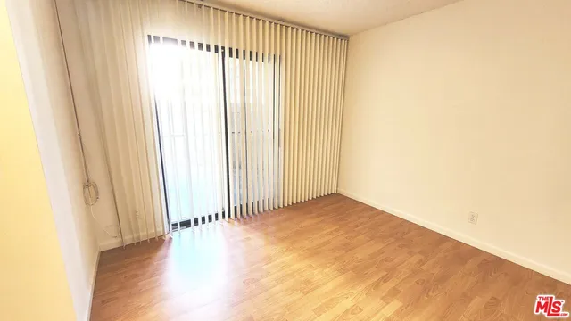 a view of a room with wooden floor and a window