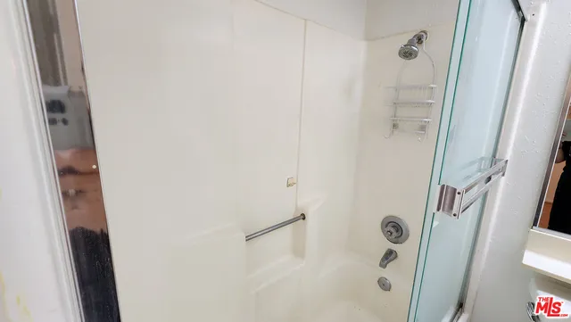 a bathroom with a shower and a mirror