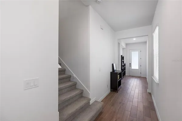 a view of a hallway with wooden floor and staircase