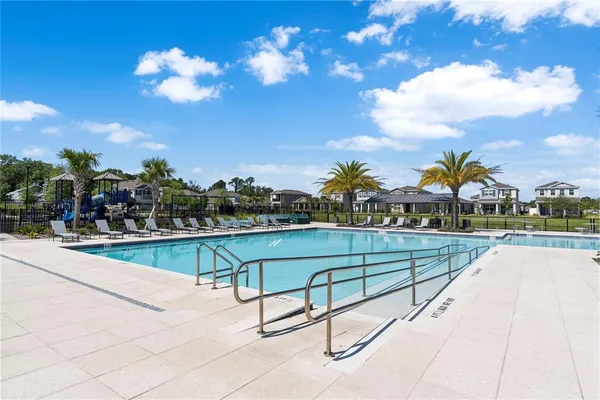 a view of swimming pool with outdoor seating and yard in back