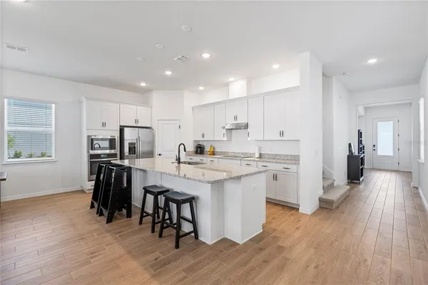 a kitchen with white cabinets and stainless steel appliances