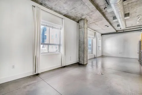 a view of a livingroom with an empty space and a window