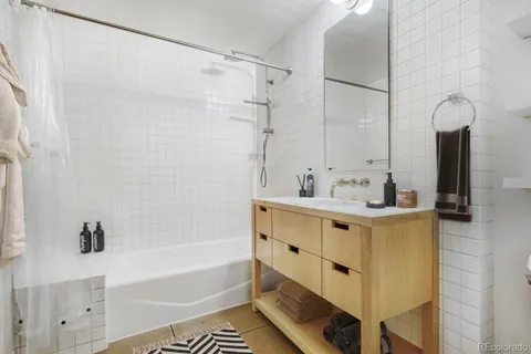 a bathroom with a tub sink and mirror