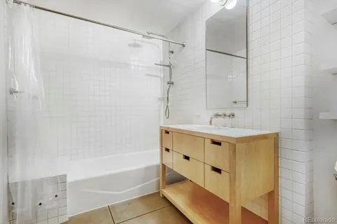 a bathroom with a tub shower and sink