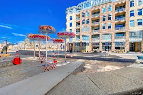 a multi story building with retail shops and potted plants