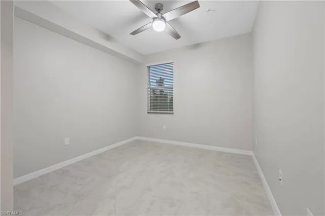 an empty room with a window and a ceiling fan