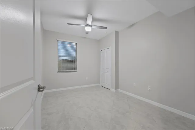 a view of an empty room with a chandelier fan