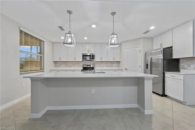 a kitchen with refrigerator and cabinets