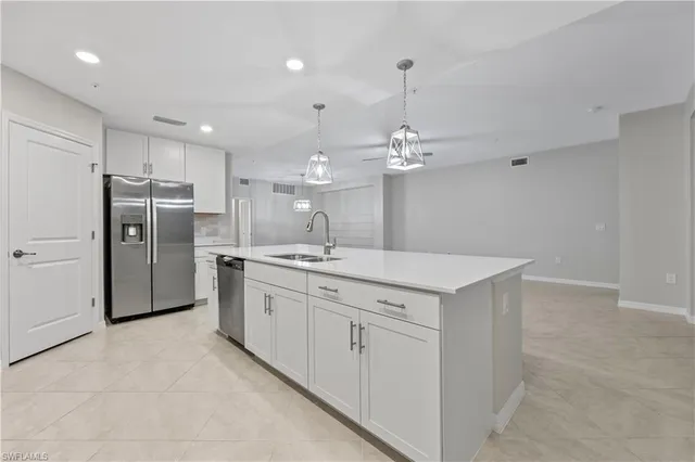 a large kitchen with a sink and refrigerator