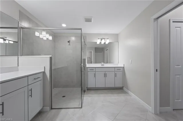 a bathroom with a double vanity sink mirror and shower
