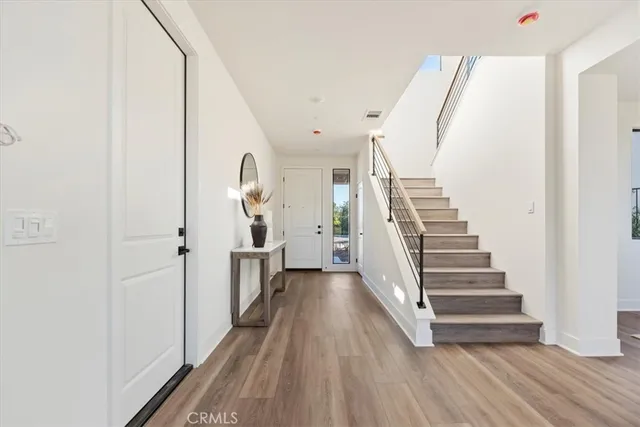 a view of a hallway with wooden floor and staircase
