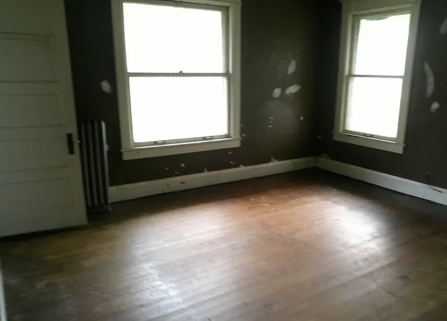 a view of a room with wooden floor and a window