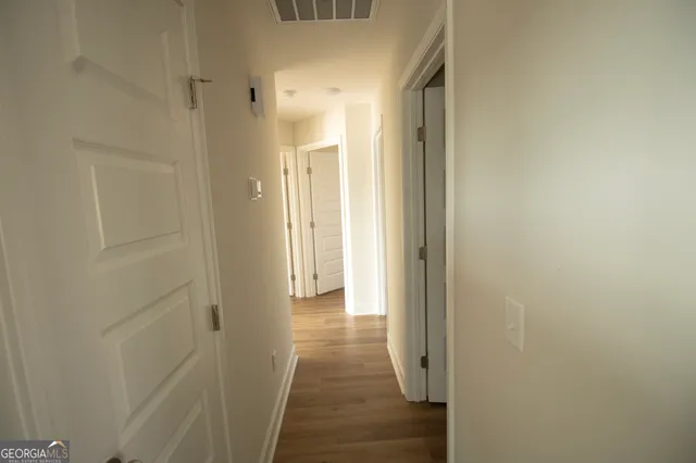 a view of a hallway with wooden floor