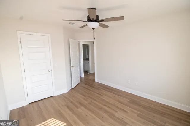 a view of empty room with wooden floor