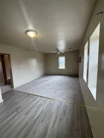 a view of empty room with window and wooden floor