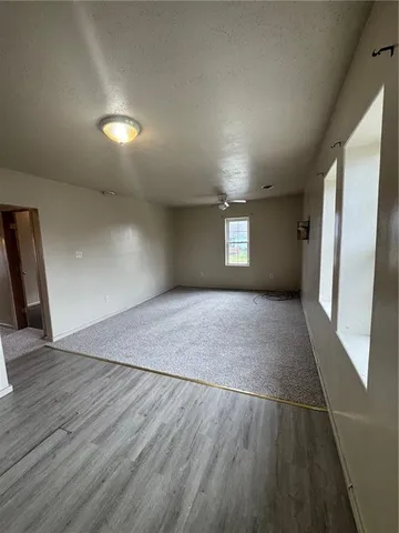 a view of empty room with window and wooden floor