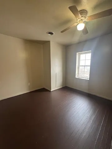 an empty room with a window and a ceiling fan