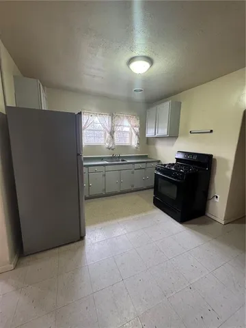 a kitchen with granite countertop a refrigerator and a stove
