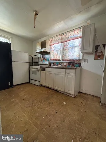a view of a hallway with wooden floor and a bathroom