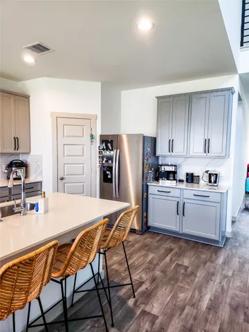 a kitchen with a refrigerator a stove a sink and white cabinets