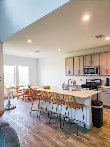 a kitchen with stainless steel appliances a table and chairs in it