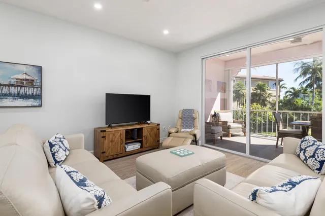 a living room with furniture a flat screen tv and a large window