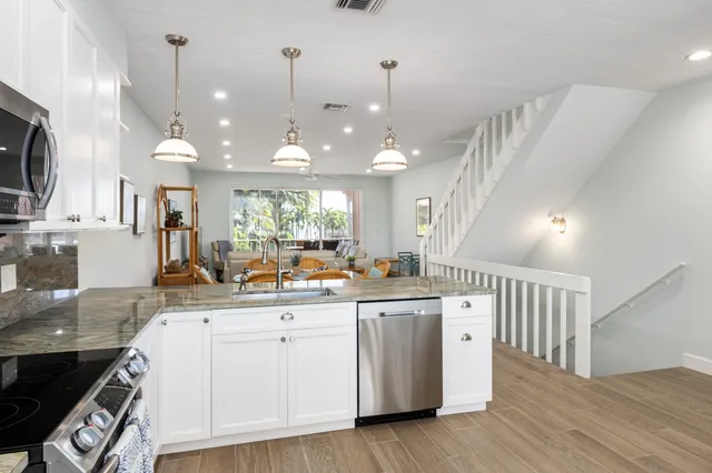 a large kitchen with a lot of counter space and wooden floor
