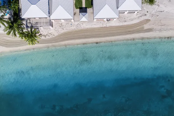 an aerial view of residential houses with yard and car parked