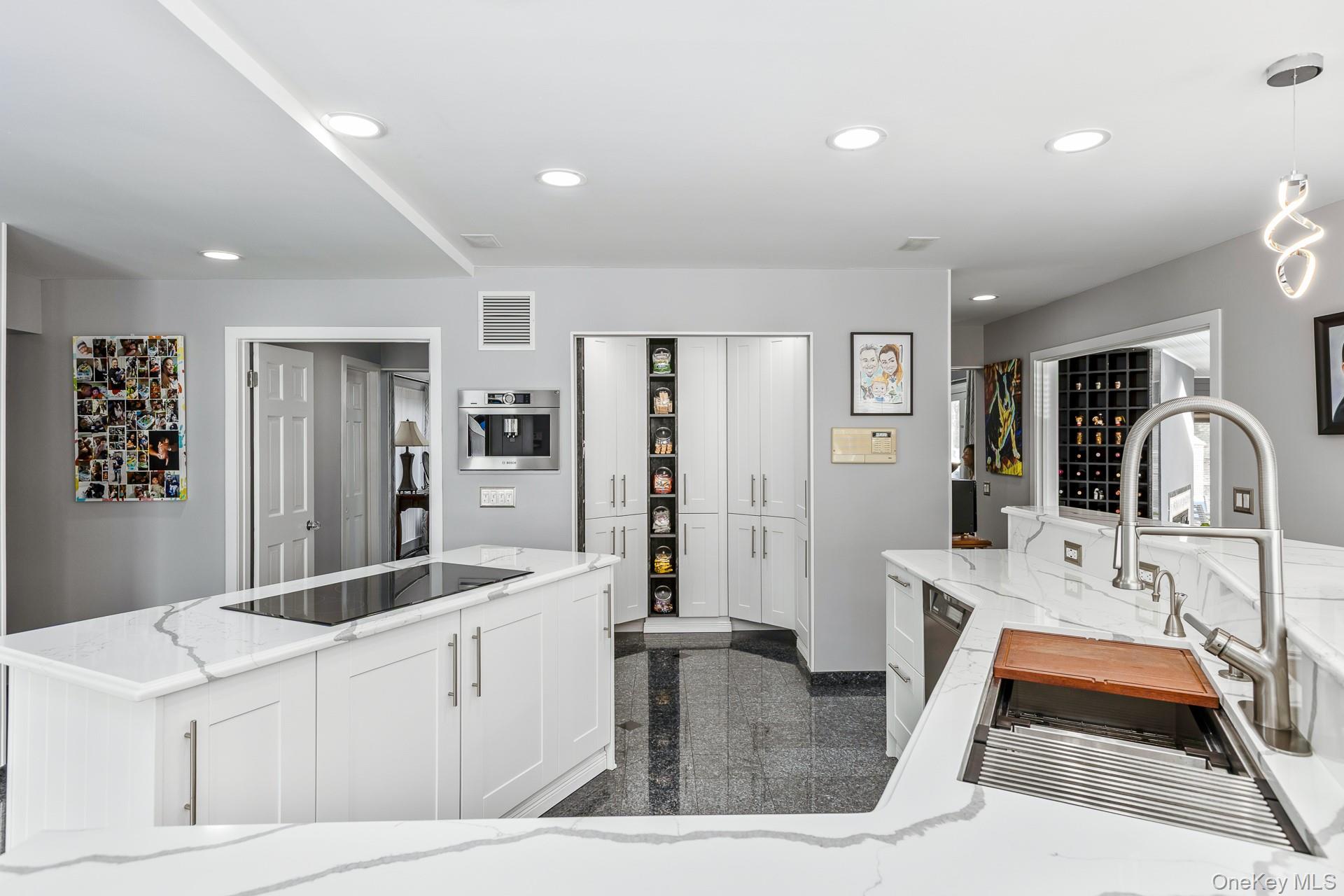 83 Cliff Road Port Jefferson, NY 11777 - Photo 30 of 50 a large white kitchen with stainless steel appliances kitchen island a large counter top and a stove