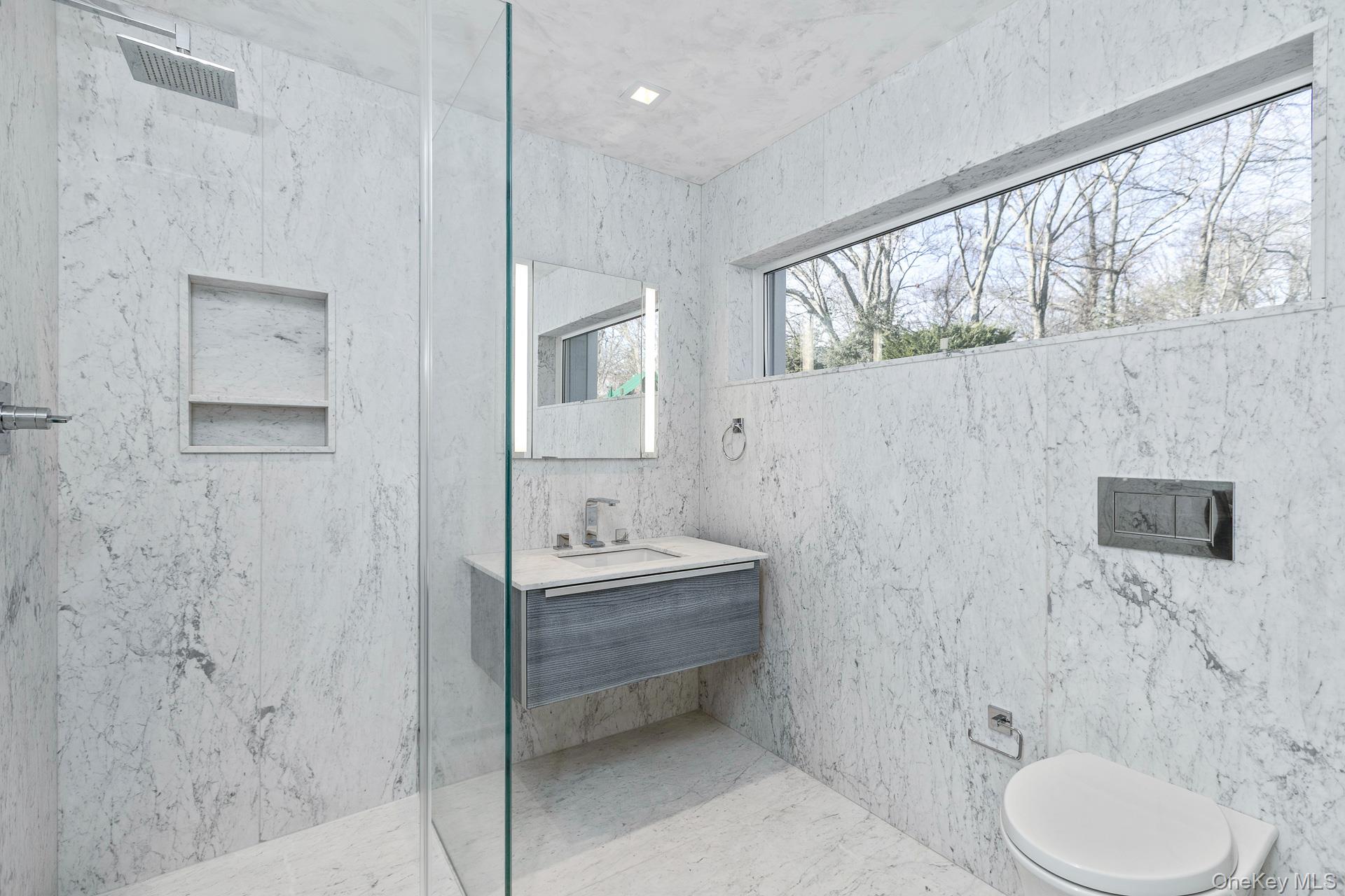 83 Cliff Road Port Jefferson, NY 11777 - Photo 36 of 50 a bathroom with a toilet sink a mirror and shower