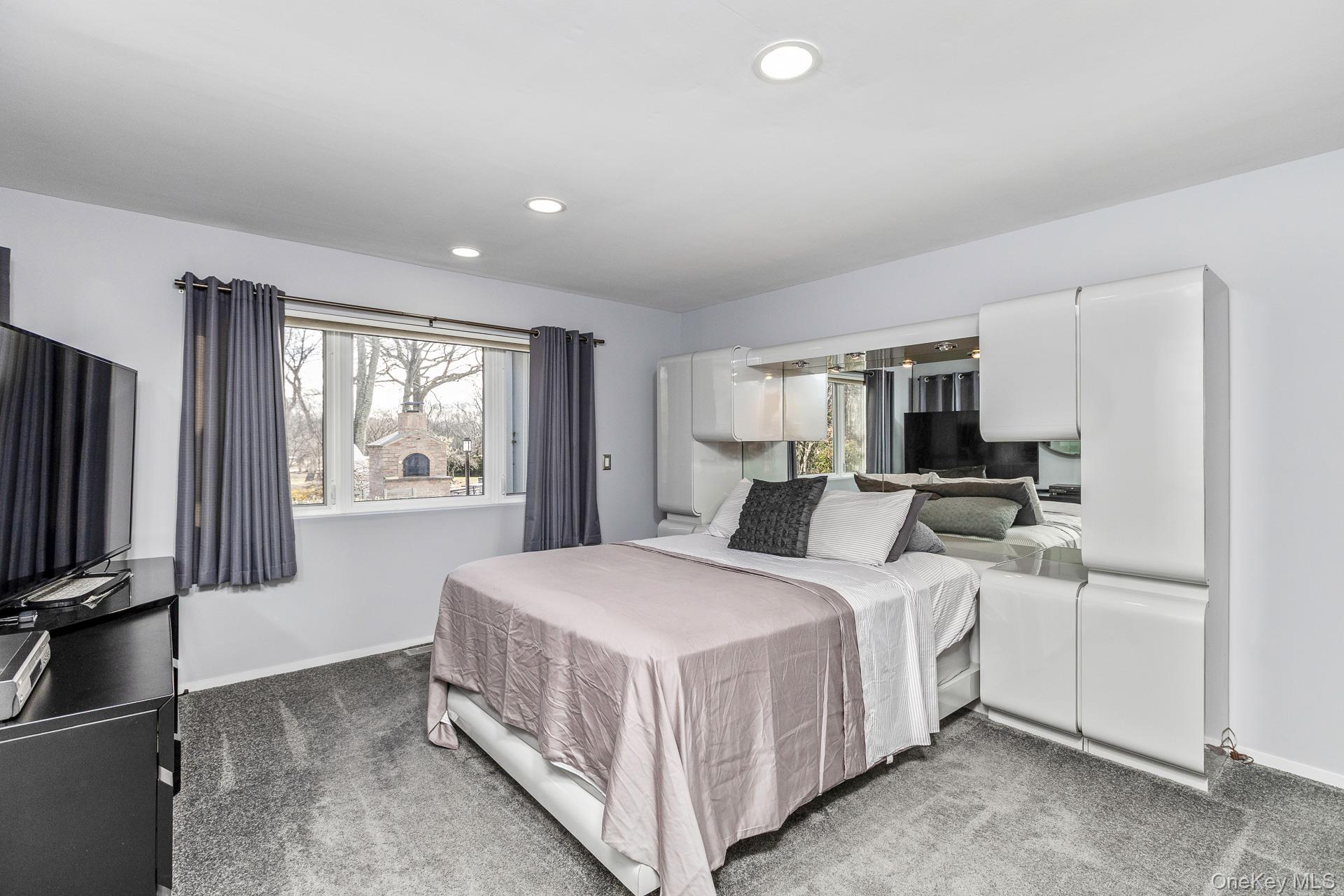 83 Cliff Road Port Jefferson, NY 11777 - Photo 39 of 50 a bedroom with a bed a window and dresser