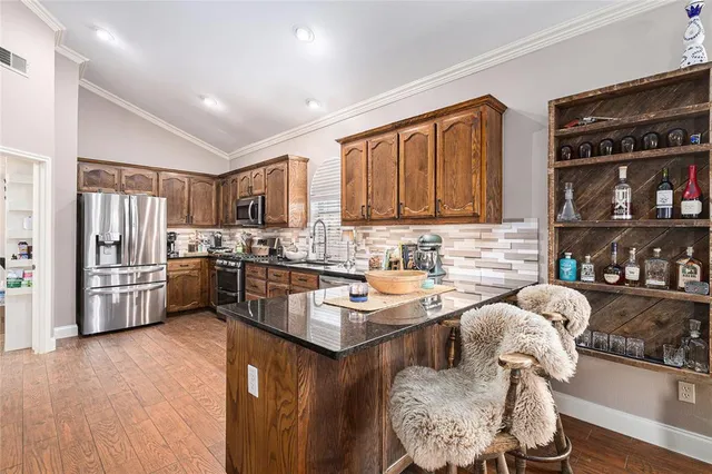a living room with stainless steel appliances furniture fireplace and flat screen tv