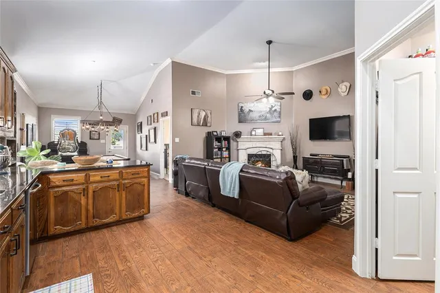 a kitchen with stainless steel appliances granite countertop a stove a sink dishwasher and cabinets with wooden floor