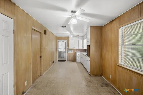 a view of a hallway with a chandelier fan and windows