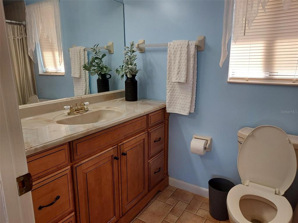 47 Lake Forest Place, Unit 47 Palm Coast, FL 32137 - Photo 6 of 12 a bathroom with a granite countertop toilet sink and mirror
