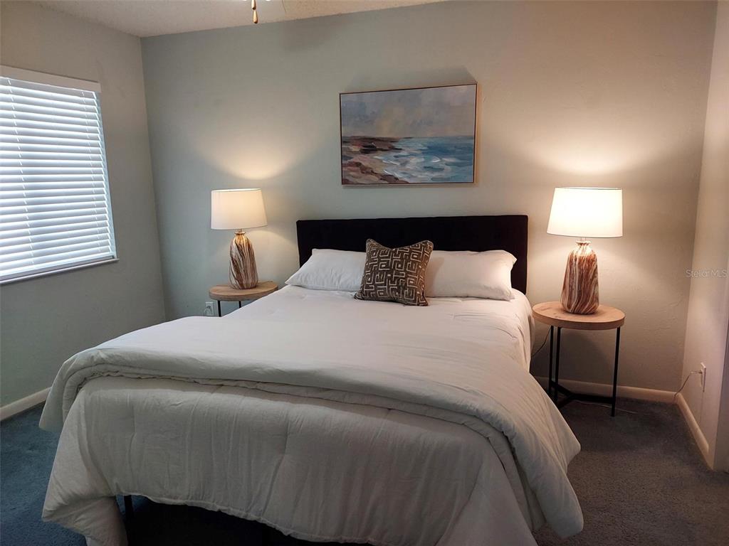 47 Lake Forest Place, Unit 47 Palm Coast, FL 32137 - Photo 8 of 12 a bedroom with a bed and lamps
