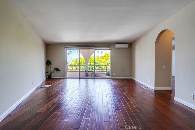 an empty room with wooden floor and a window