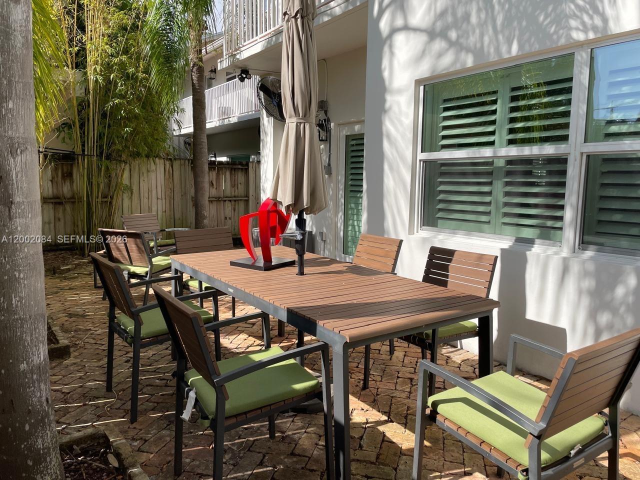 3081 Matilda Street, Unit A Miami, FL 33133 - Photo 14 of 14 a view of a dining table and chairs in the patio