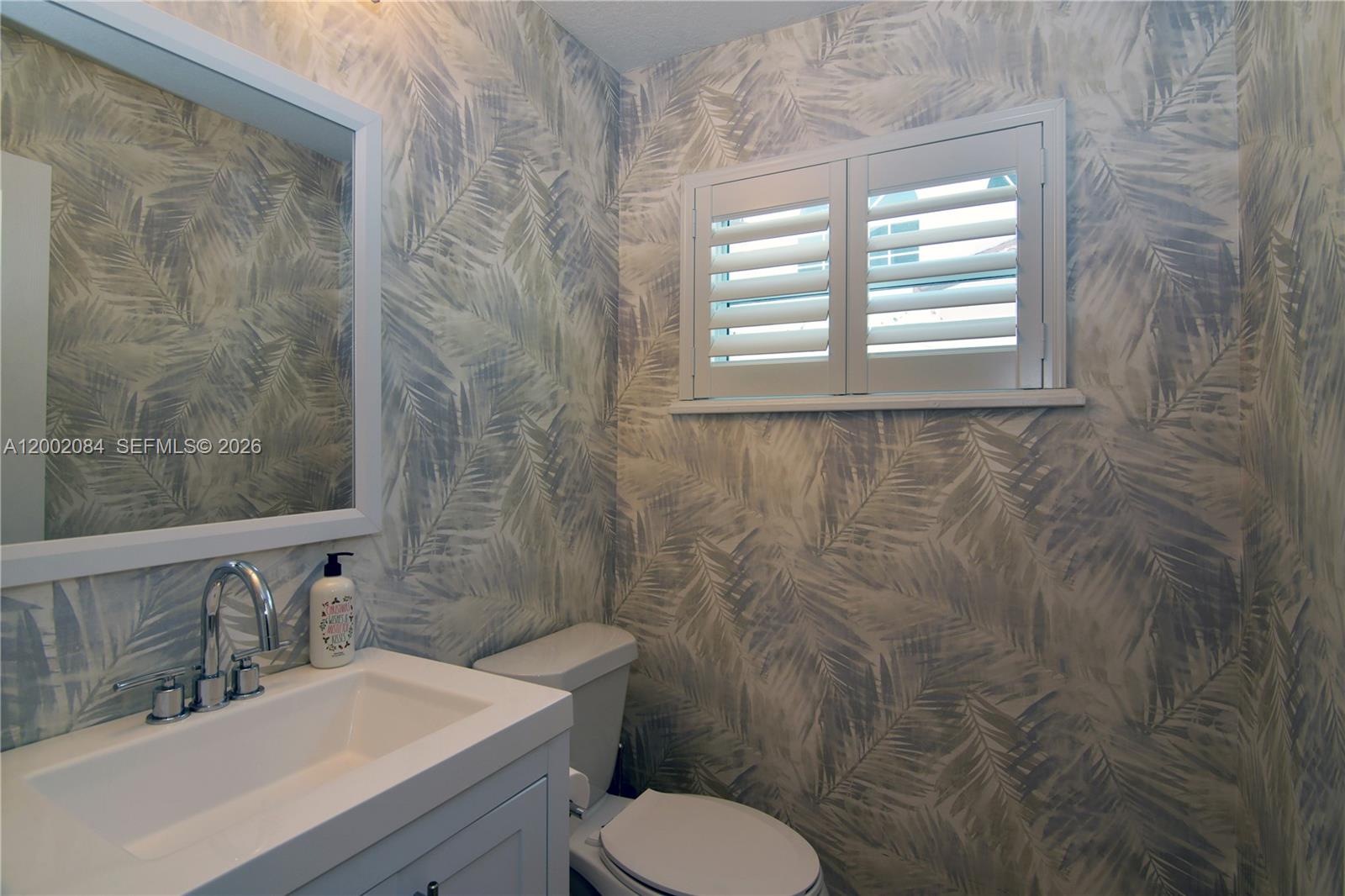 3081 Matilda Street, Unit A Miami, FL 33133 - Photo 10 of 14 a bathroom with a sink a toilet and a mirror