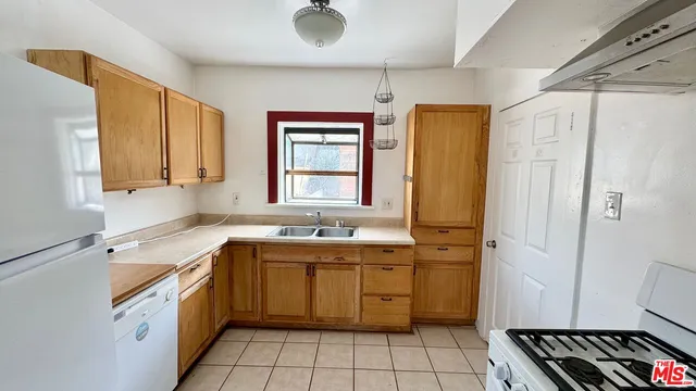 a kitchen with a sink appliances cabinets and a window